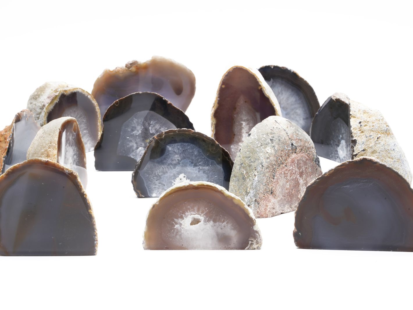 A collection of polished agate nodules in various colors and patterns, showcasing their smooth surfaces and natural formations. The stones are arranged prominently against a white background, highlighting their unique textures.