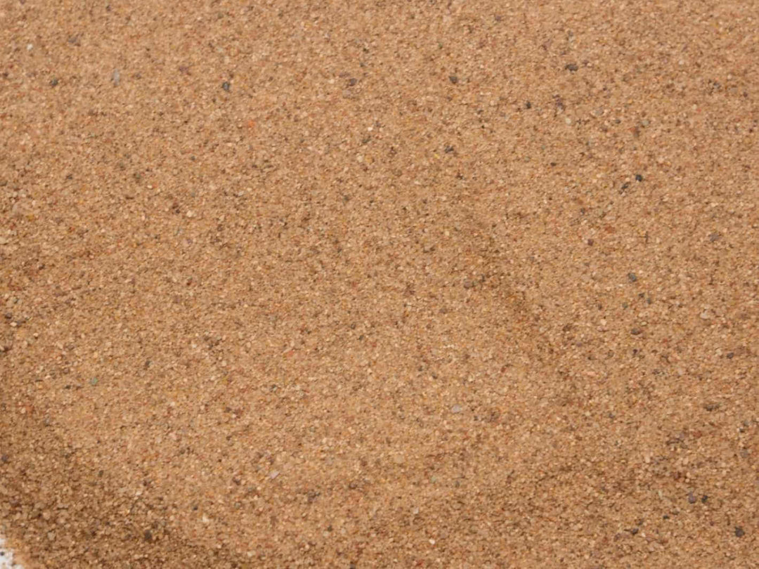 Natural earthy desert sand pile on white background showing fine decorative texture