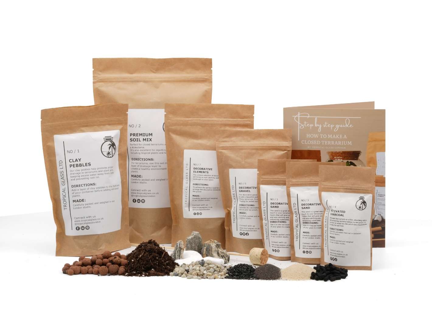 A variety of terrarium supplies is displayed on a white background, including packets of clay pebbles, premium soil mix, and decorative stones.
