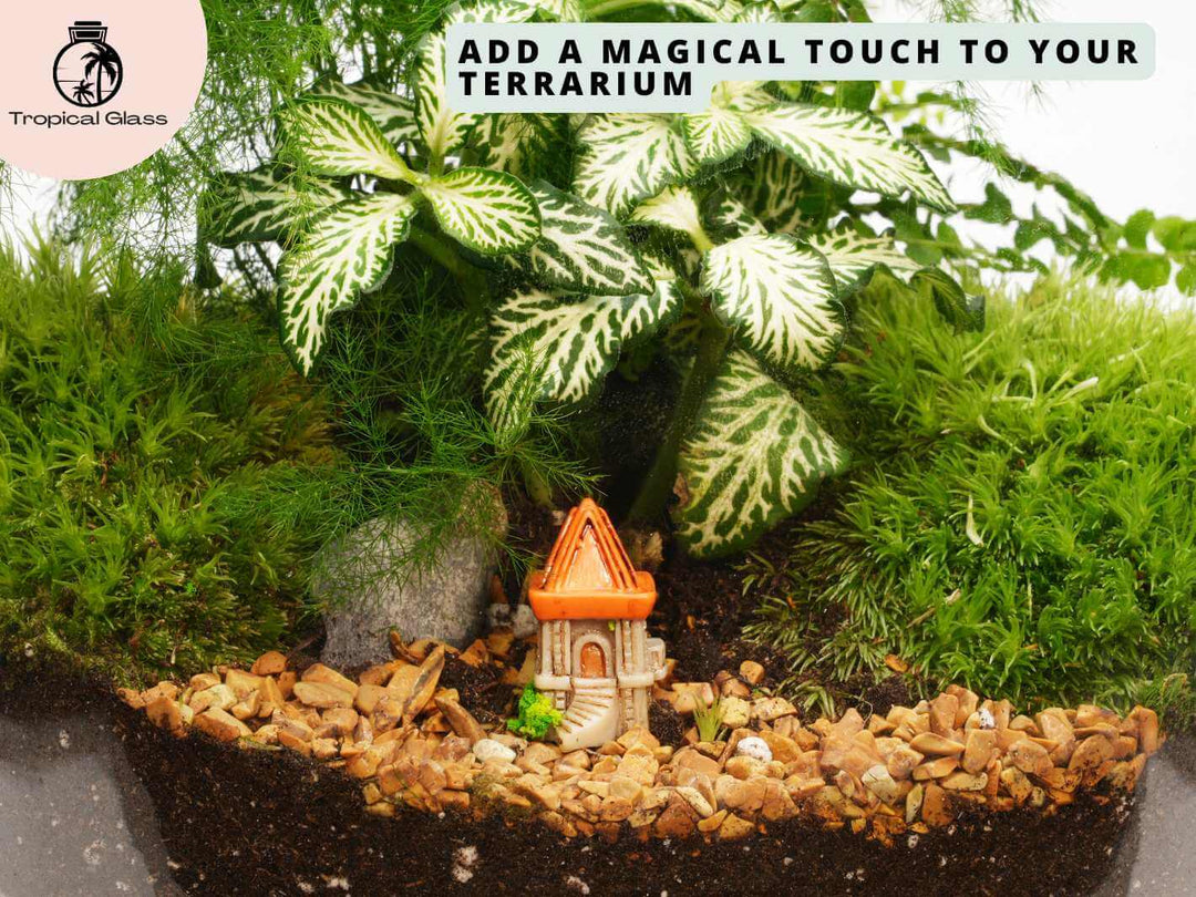Mini castle tower figurine placed inside a terrarium with moss, gravel and tiny plants