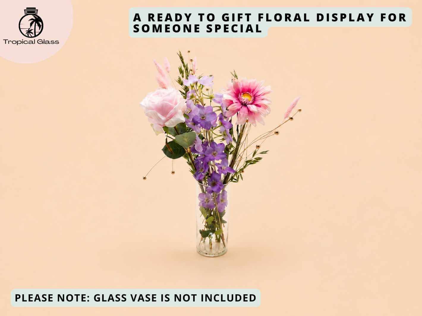 Dried and artificial flower arrangement displayed in a glass vase