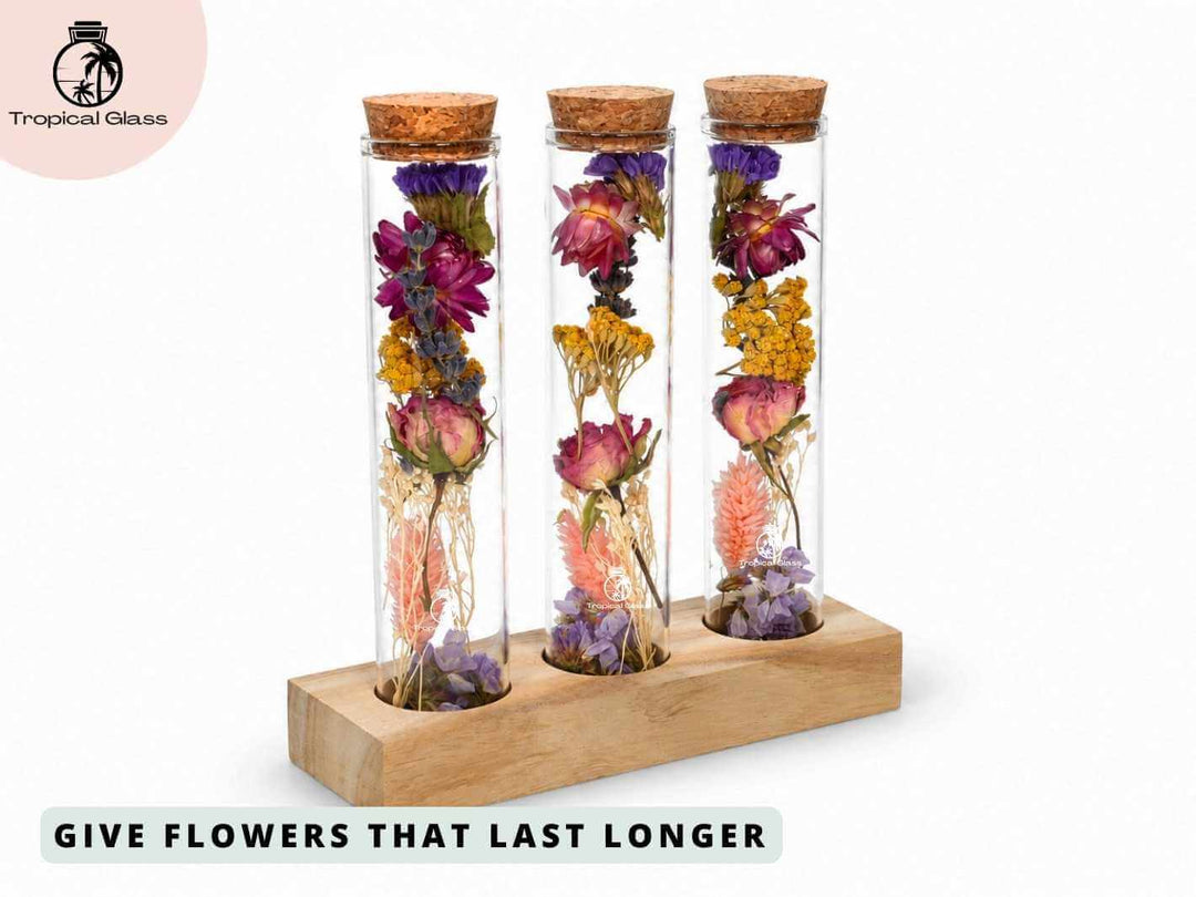 A wooden stand holds three glass test tubes filled with an assortment of dried flowers, displaying vibrant colors and varied textures. The cork tops add a rustic touch, making this arrangement a charming decorative piece.