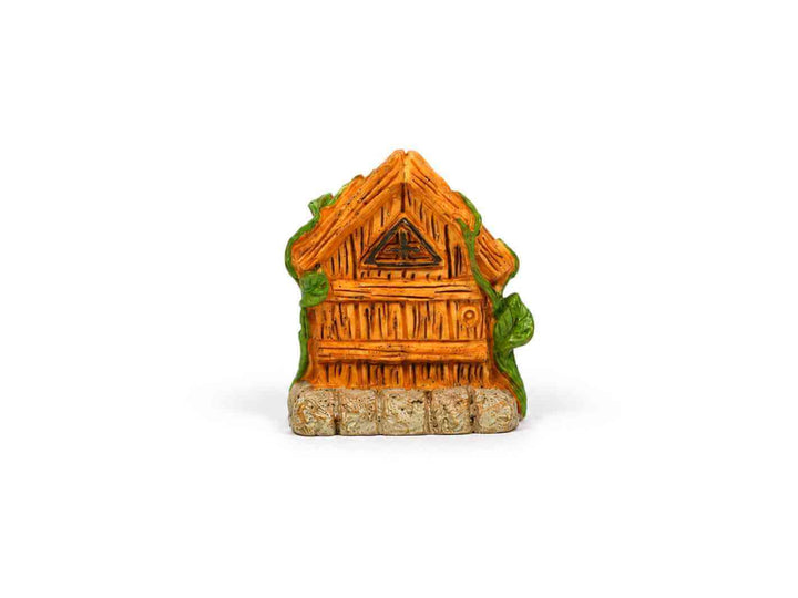 Front view of a miniature wooden fairy house with carved details, green vines, and stone base
