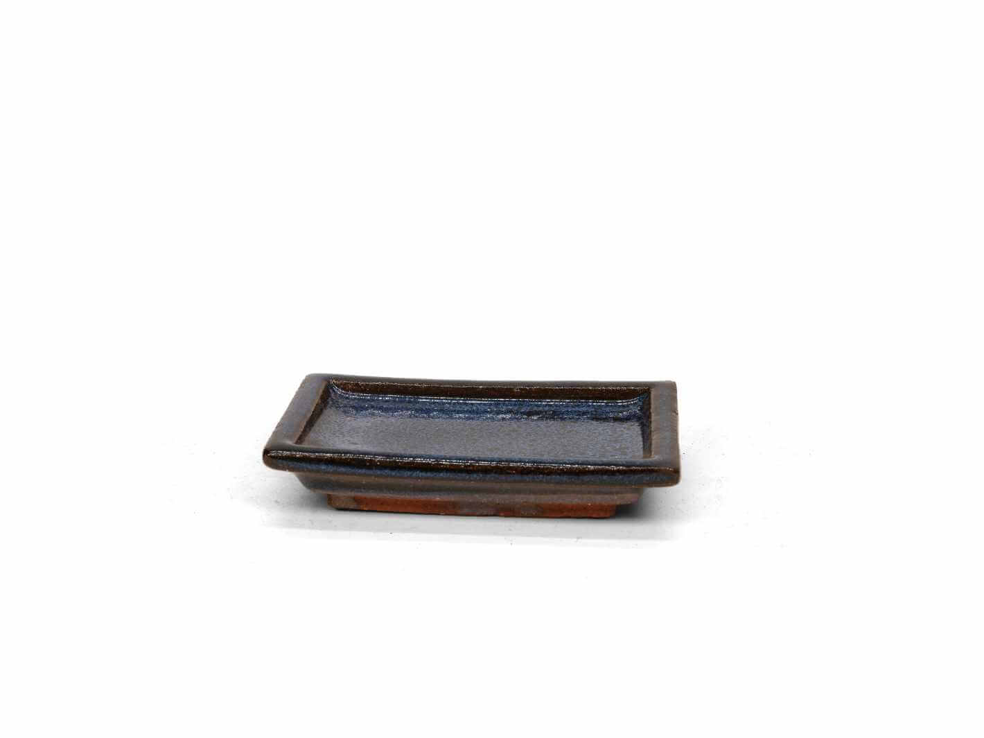 Handmade ceramic drip tray saucer with deep blue glaze on white background