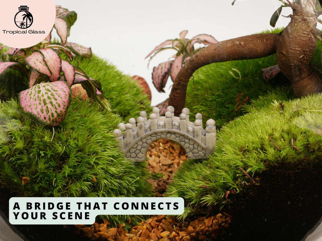 Mini bridge figurine placed inside terrarium, decorative miniature scene with plants and moss