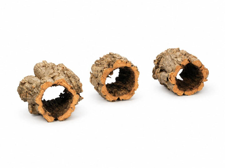 Three natural cork bark tunnels with hollow centers, showing rough brown outer bark and tan inner wood, arranged on a plain white background.