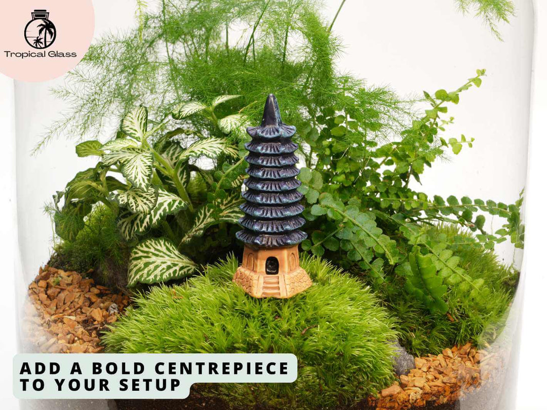 Mini pagoda tower ornament in terrarium surrounded by moss, detailed miniature landscape scene