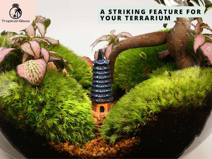 Mini pagoda tower ornament placed inside terrarium, miniature scene with plants and natural elements