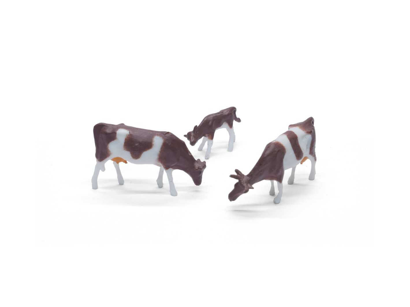 Small cow figurine, ideal for creating a realistic barnyard or countryside scene in miniature setups.