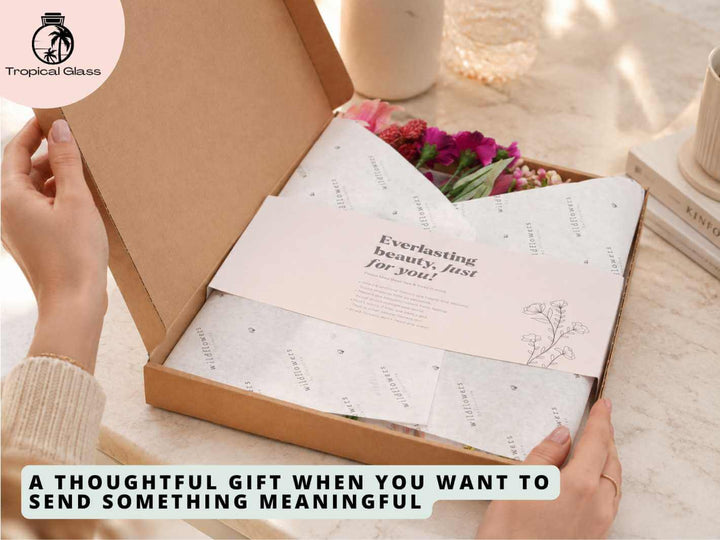 Person opening a red letterbox flower gift box with dried and artificial flower stems inside