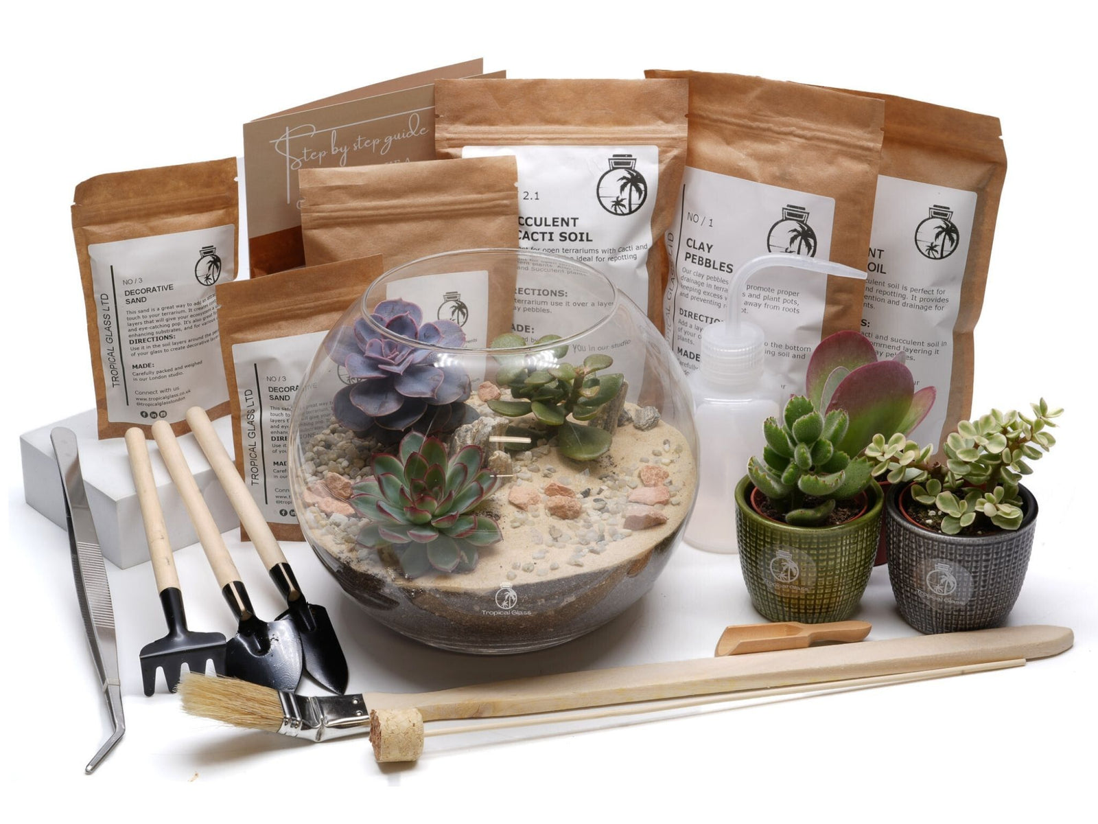 A DIY Fishbowl Terrarium Kit is displayed, featuring a round glass terrarium filled with soil, pebbles, and various succulents.
