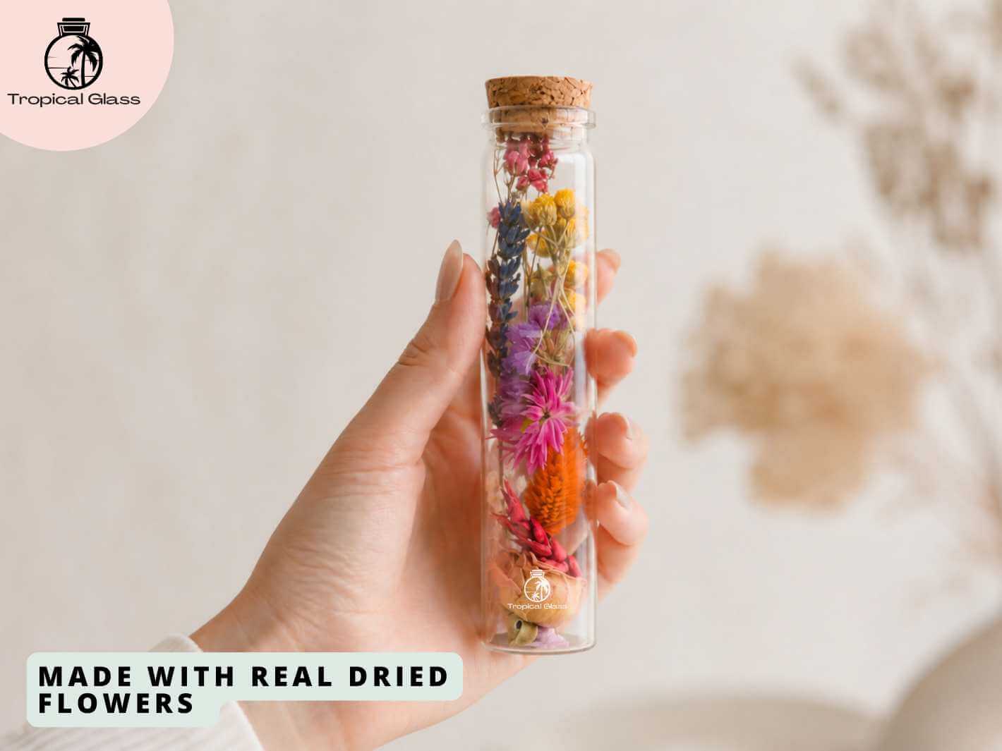 Woman holding a dried flower glass bottle in her hand, showing the compact decorative size and floral detail