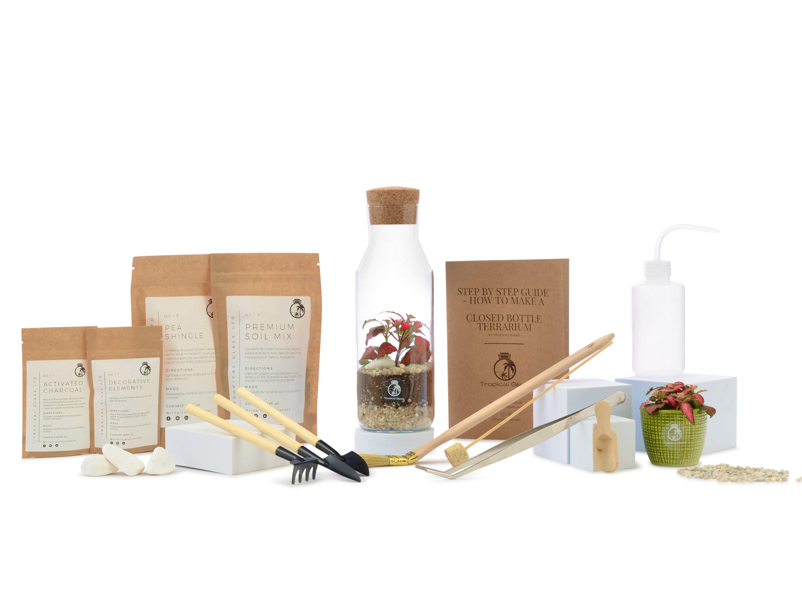 A DIY terrarium kit is displayed, featuring a 27 cm glass jar with plants, soil mix, decorative stones, and tools for assembly. The kit includes a guide for creating a terrarium, making it a unique home or office decoration.