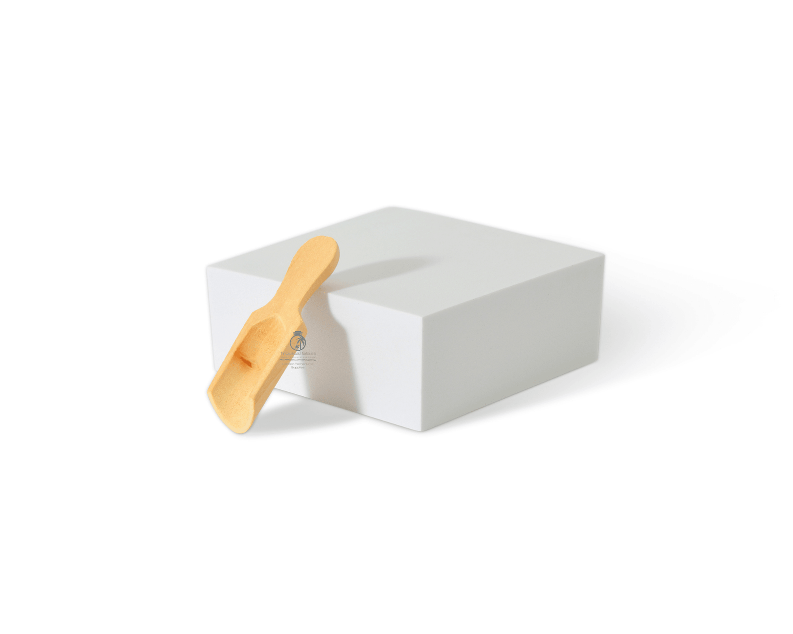 A handcrafted wooden scoop shovel made from sustainable Beechwood is positioned on a white cube. The scoop features an ergonomic design and a small, shallow bowl, perfect for precise pouring in gardening tasks.
