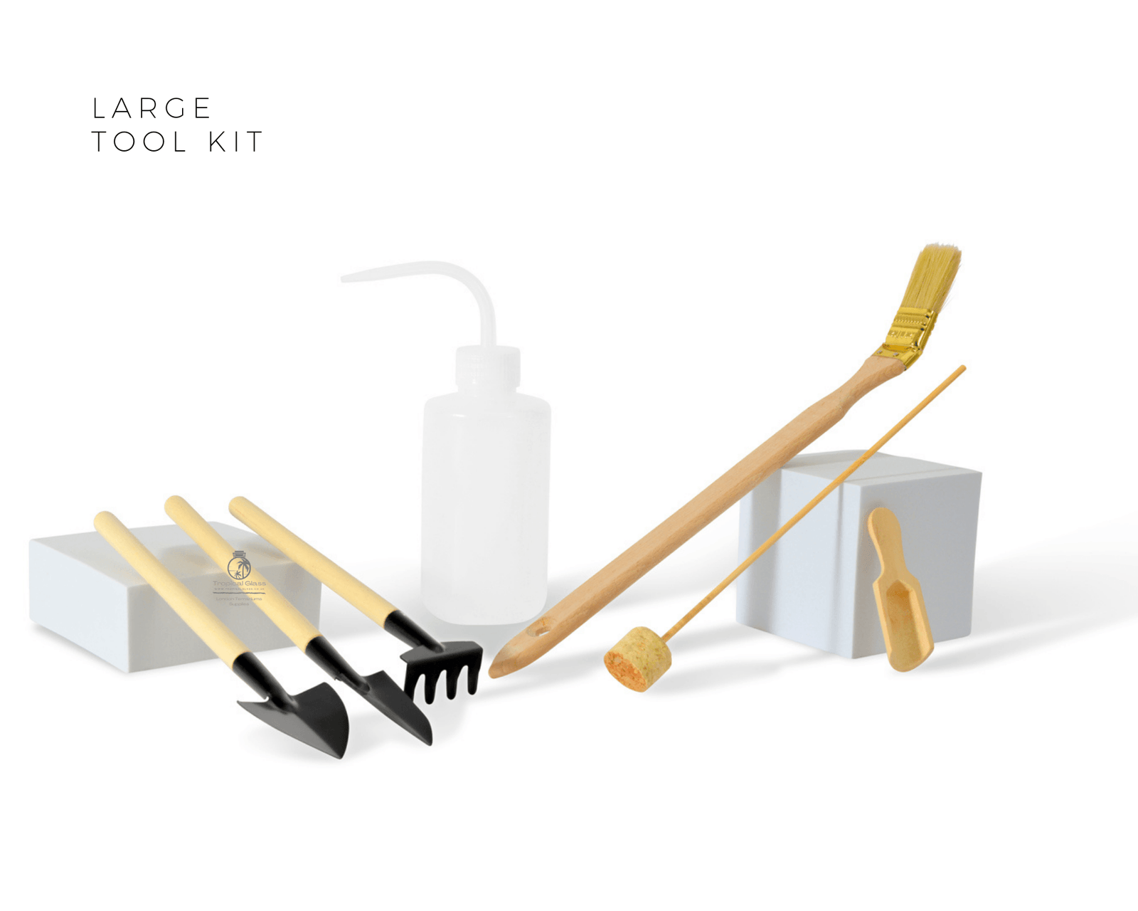 A large garden tool kit featuring seven pieces, including a shovel, rake, spade, brush, cork tamper, and a watering bottle.